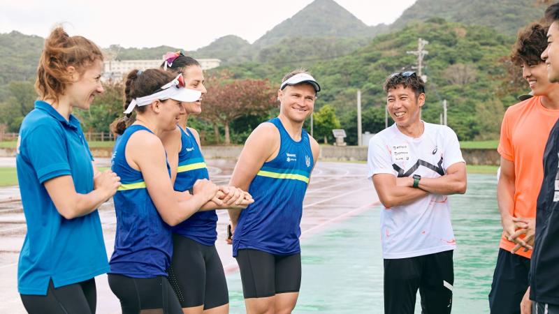 Four Para triathletes and official from Ukraine are speaking with Japanese athletes